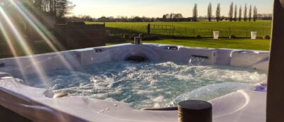 Jacuzzi spa buiten met wat erin dat aan het bubbelen is. Buiten is er een mooi uitzicht op land