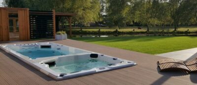 Een ingebouwde jacuzzi spa op een houten vlonder buiten op een zonnige dag