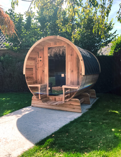 Barrelsauna in de buitenlucht met zon en groene natuur op de achtergrond