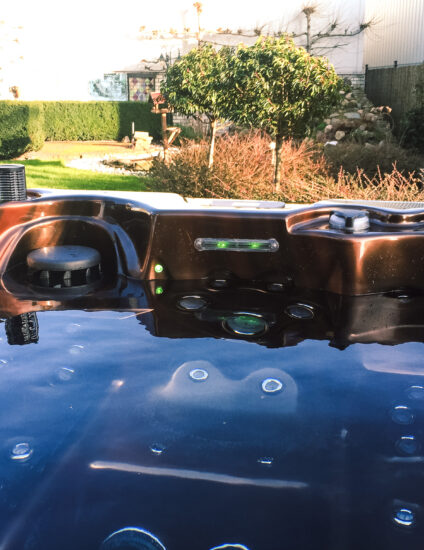 jacuzzi met bruine binnenkant, gevuld met water en uitzicht op een tuin