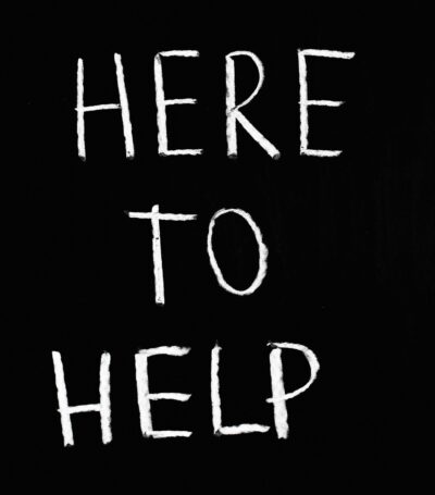 Zwarte achtergrond met witte tekst "here to help"