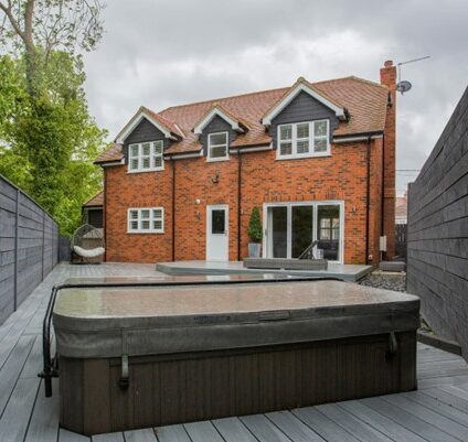 jacuzzi in de achtertuin van oranje huis. de jacuzzi is afgedekt
