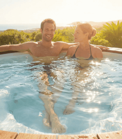 Een man en een vrouw die samen in een jacuzzi zitten te genieten in de zomer terwijl de zon schijnt in de achtergrond