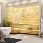 Luxe badkamer met een ingebouwde combi sauna van licht hout, omgeven door witte tinten