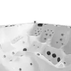 Binnenaanzicht van een witte spa met meerdere zitplaatsen, ergonomische vormen en diverse massagejets op verschillende hoogtes.