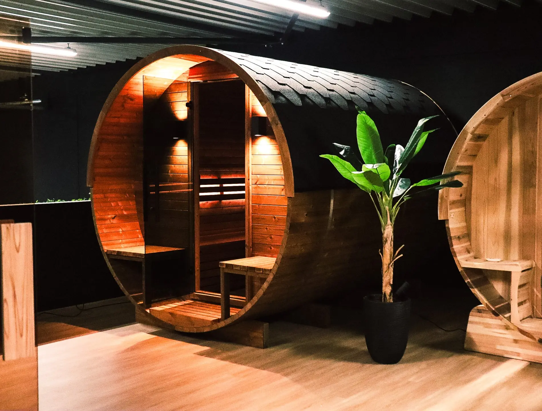 Houten barrelsauna met ronde vorm en verlichte binnenruimte