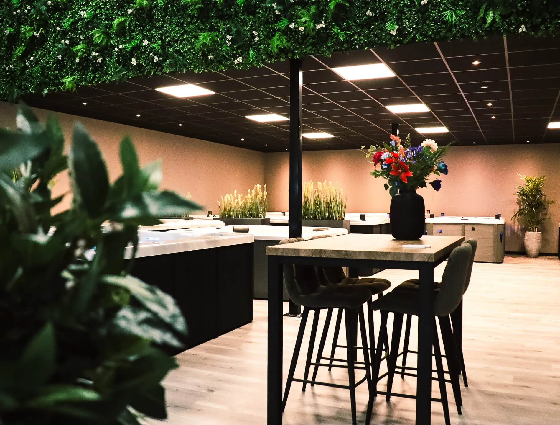 Showroom Wellnesshuis Benelux met meerdere jacuzzi’s, zitgedeelte en groene planten