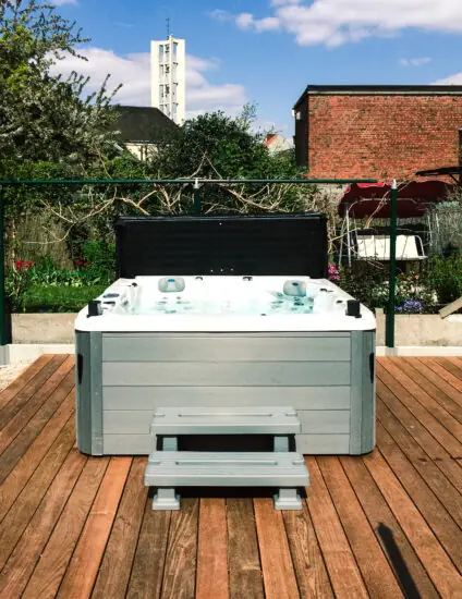 Buitenjacuzzi op houten terras in de tuin met open afdekking