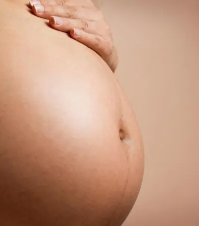 zwangere buik met een hand op haar buik